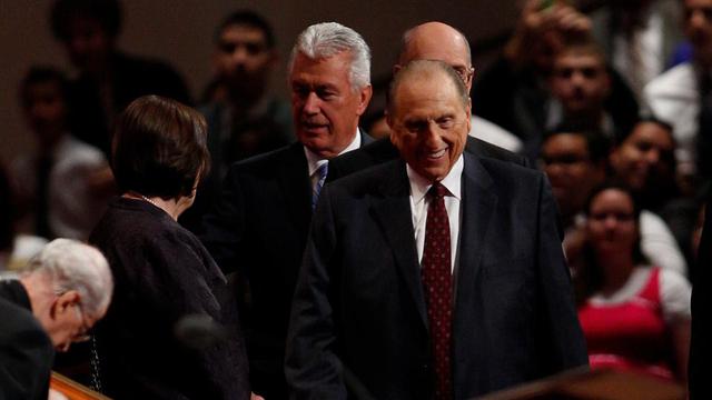 President Thomas S. Monson ler när han går in i konferenscentret innan lördagens förmiddagsmöte av generalkonferensen inleds den 5 oktober 2013.