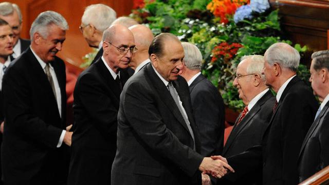 President Thomas S. Monson tar äldste Robert D. Hales i hand efter ett möte under generalkonferensen i oktober 2010.